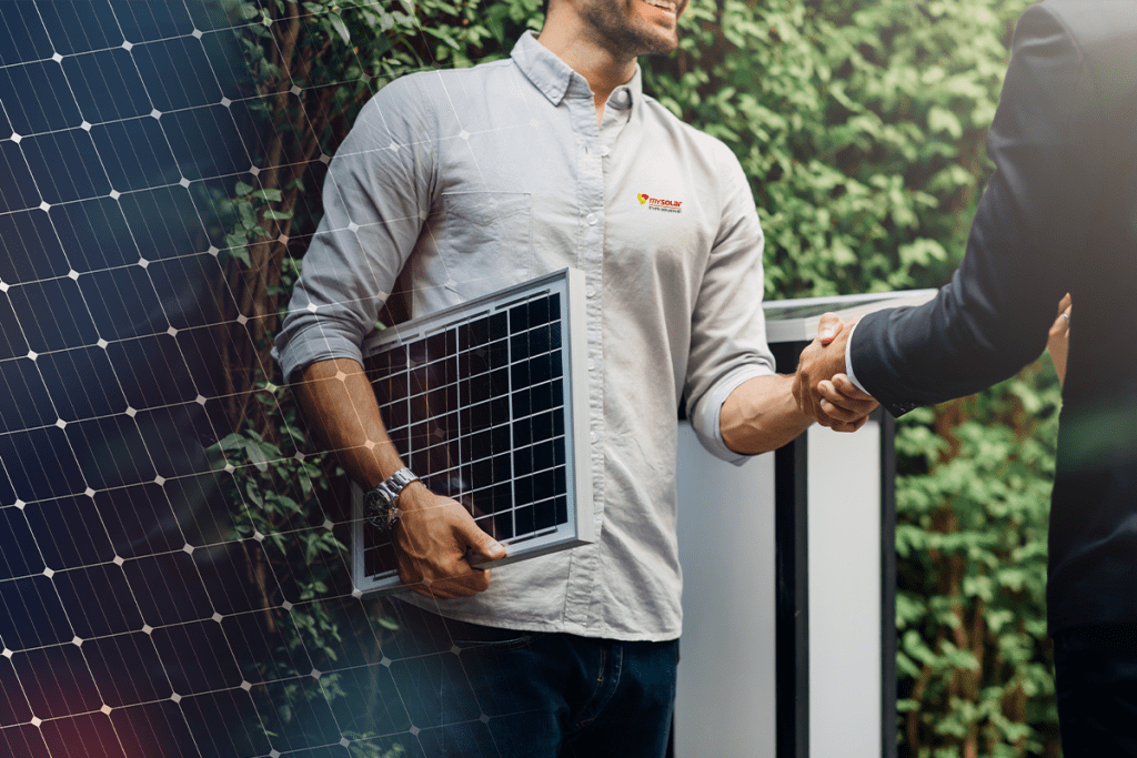 MySolar PV Jobs Photovoltaiklösung gefunden - Mitarbeiter schüttelt Kunden die Hand und hält ein Photovoltaik Panel.